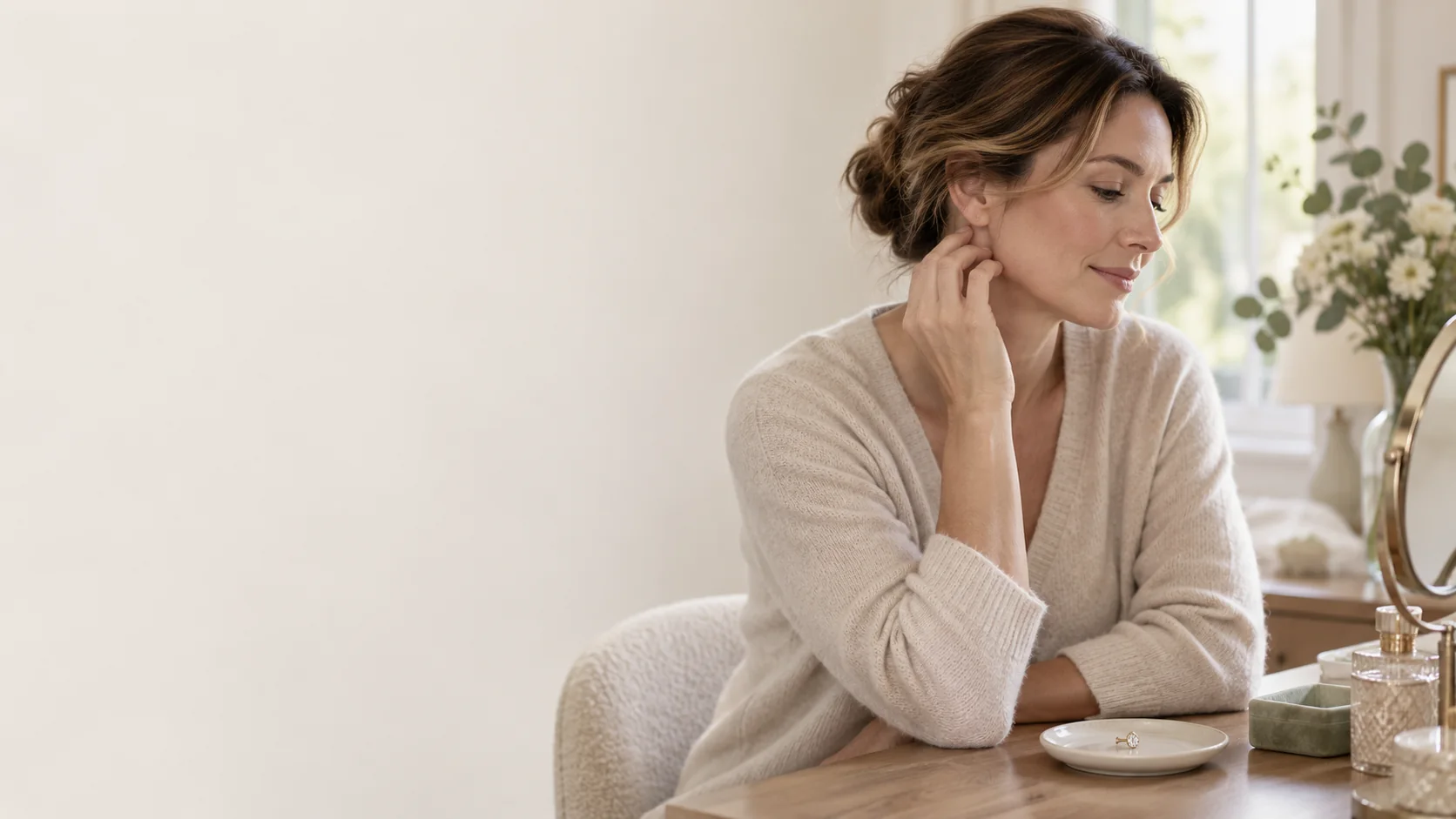 A fictional adult woman with one ear visible in a quiet home setting.